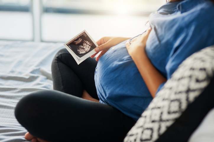 Closeup shot of an unrecognizable pregnant woman holding an ultrasound scan