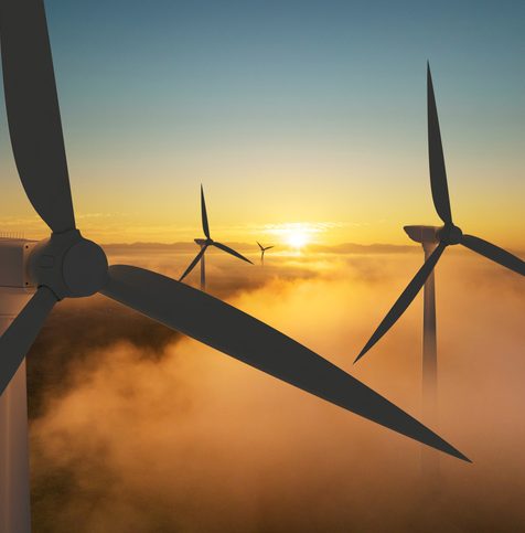 Wind turbine silhouette at sunrise, wind energy and nature concept.